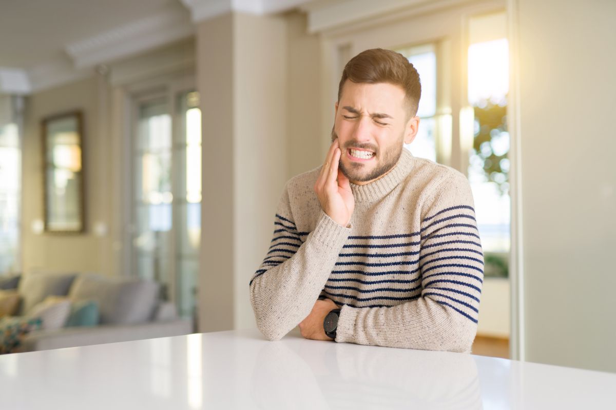 Young,Handsome,Man,At,Home,Touching,Mouth,With,Hand,With why cold air hurts your teeth